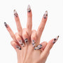 Close-up of hands with long, abstract marble-patterned nails featuring gold flakes and rhinestone accents