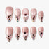 Set of pink glittery press-on nails with heart-shaped jewels, bows, and multicolor confetti accents