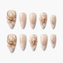 Set of glittery nude and gold artificial nails with 3D floral and pearl accents