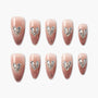 Handmade pink and brown press-on nails with rhinestone heart accents and glitter tips