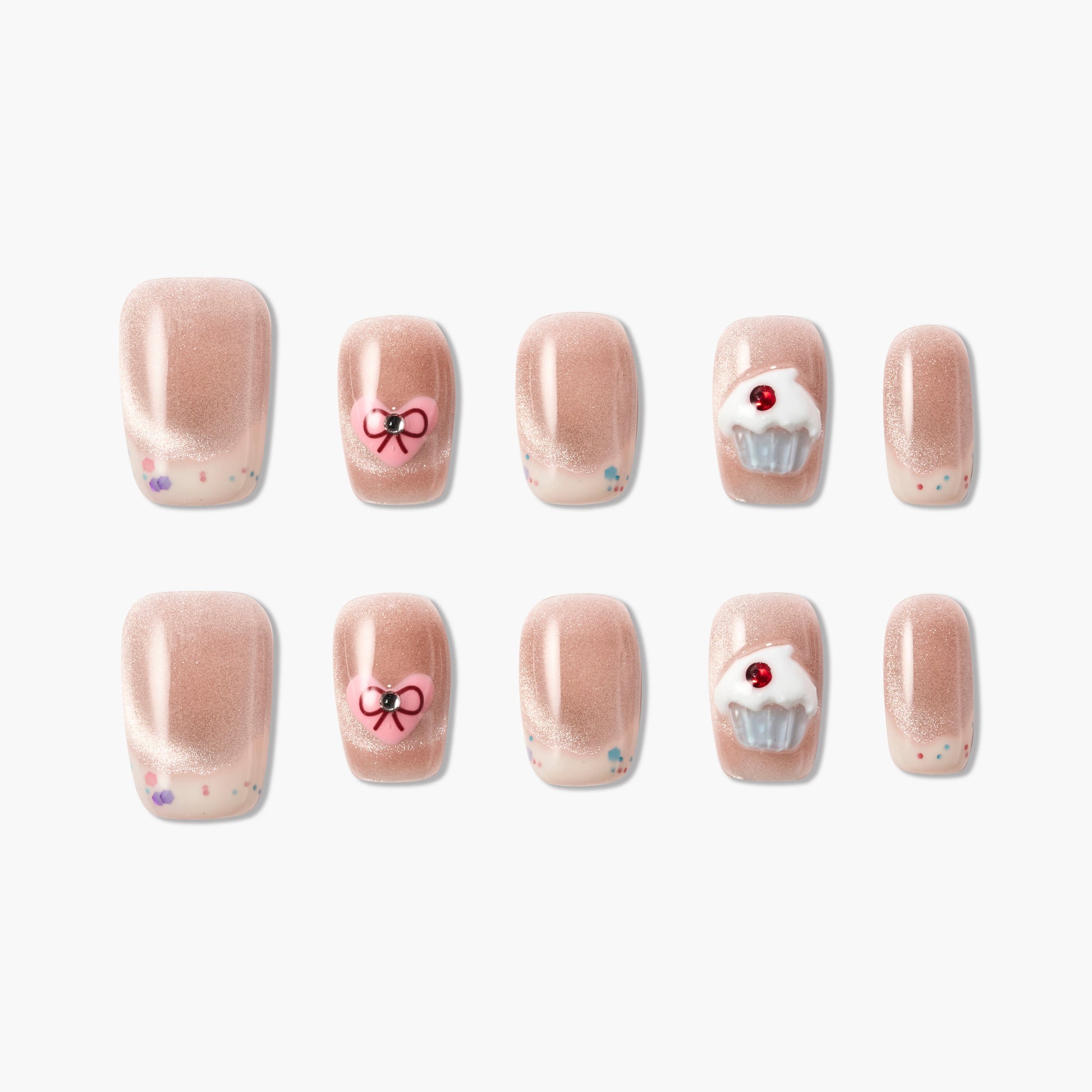 Set of glittery nude fake nails with cupcake and heart designs on white background