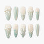 Elegant false nails set with pastel green ombre, pearl accents, 3D bows, flowers, and argyle patterns