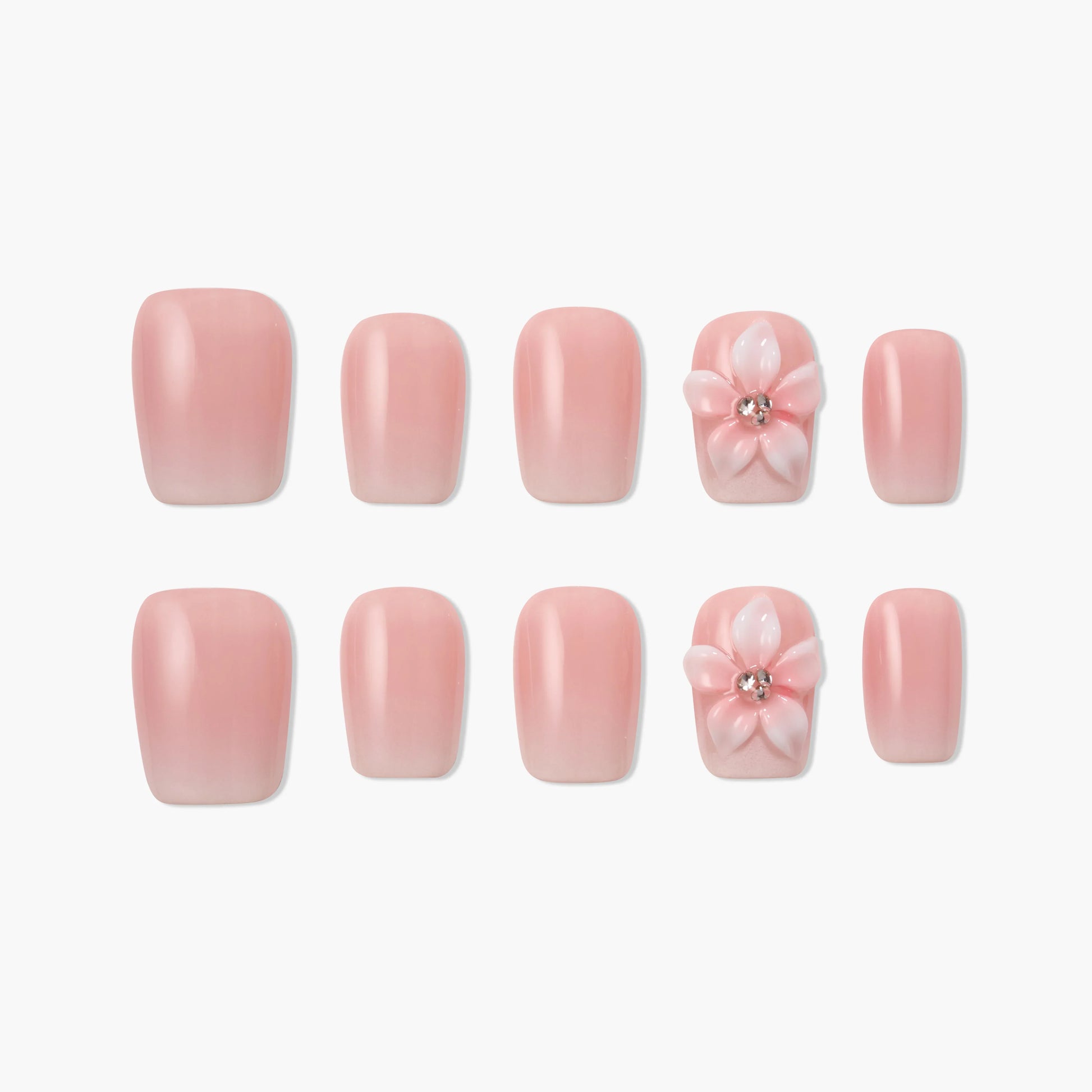 Handmade pink press-on nails with 3D flower and rhinestone accent, arranged on white background