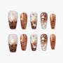 Handmade press-on nails with brown ombré, star accents, and abstract designs.