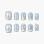 Handmade press-on nails with iridescent stars and silver glitter bows on pastel blue background
