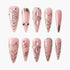 Set of pink glitter press-on nails with silver accents, floral and heart designs, and rhinestone details