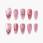 Set of pink press-on nails with glitter, heart and moon embellishments, grid patterns, and cute bear faces