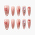 Set of pink press-on nails with red floral and crystal embellishments on white background