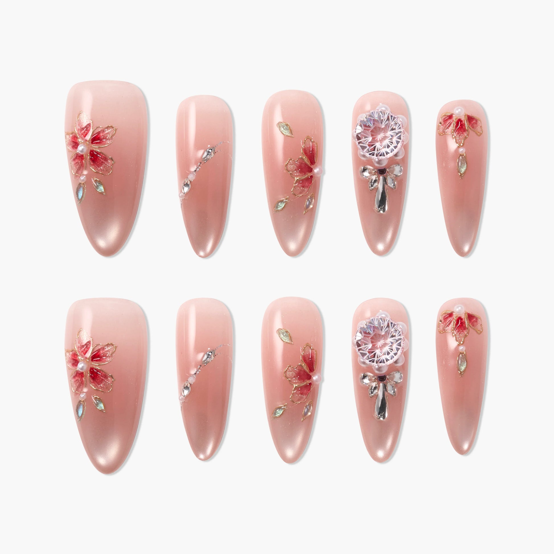Set of pink press-on nails with red floral and crystal embellishments on white background