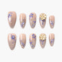 Set of beige press-on nails with intricate purple floral designs and pearl accents