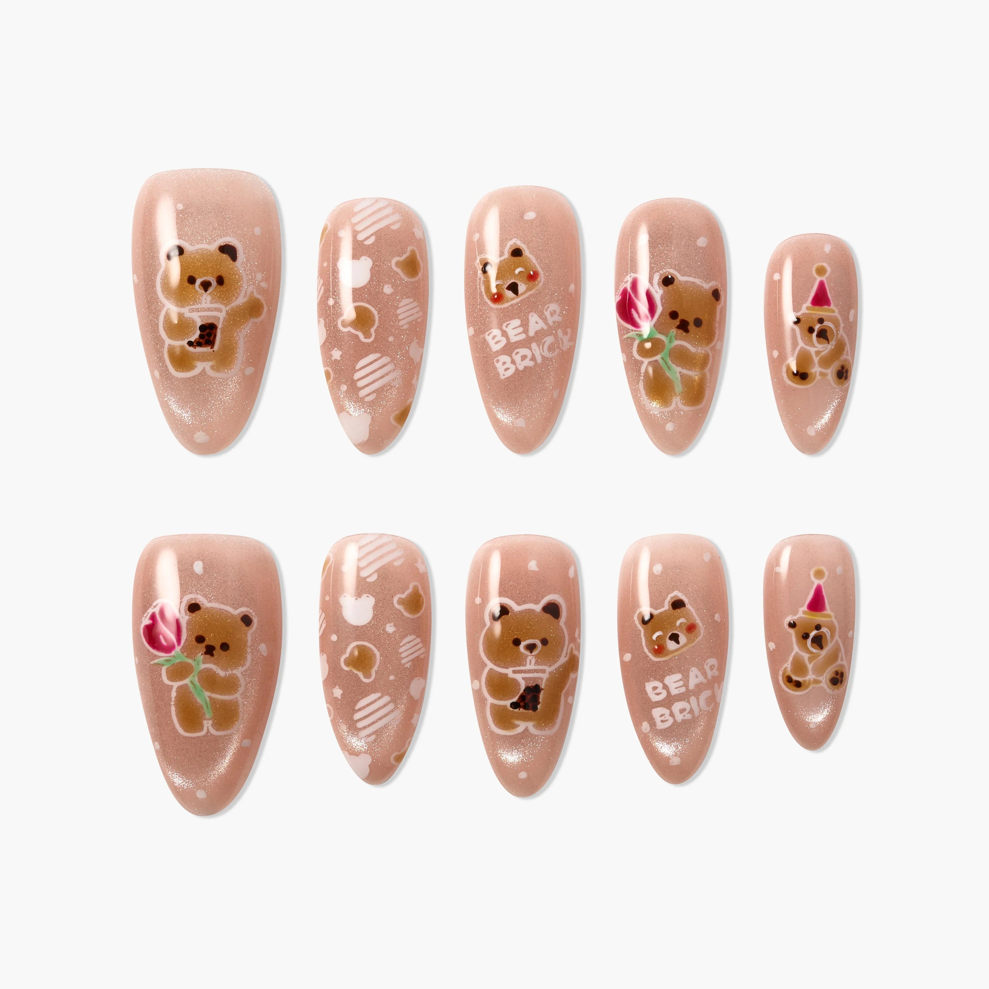 Press-on nails with cute bear designs, glittery nude base, bubble tea, rose, and party hat accents