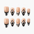 Set of nude press-on nails with black and white floral designs and 3D flower embellishments