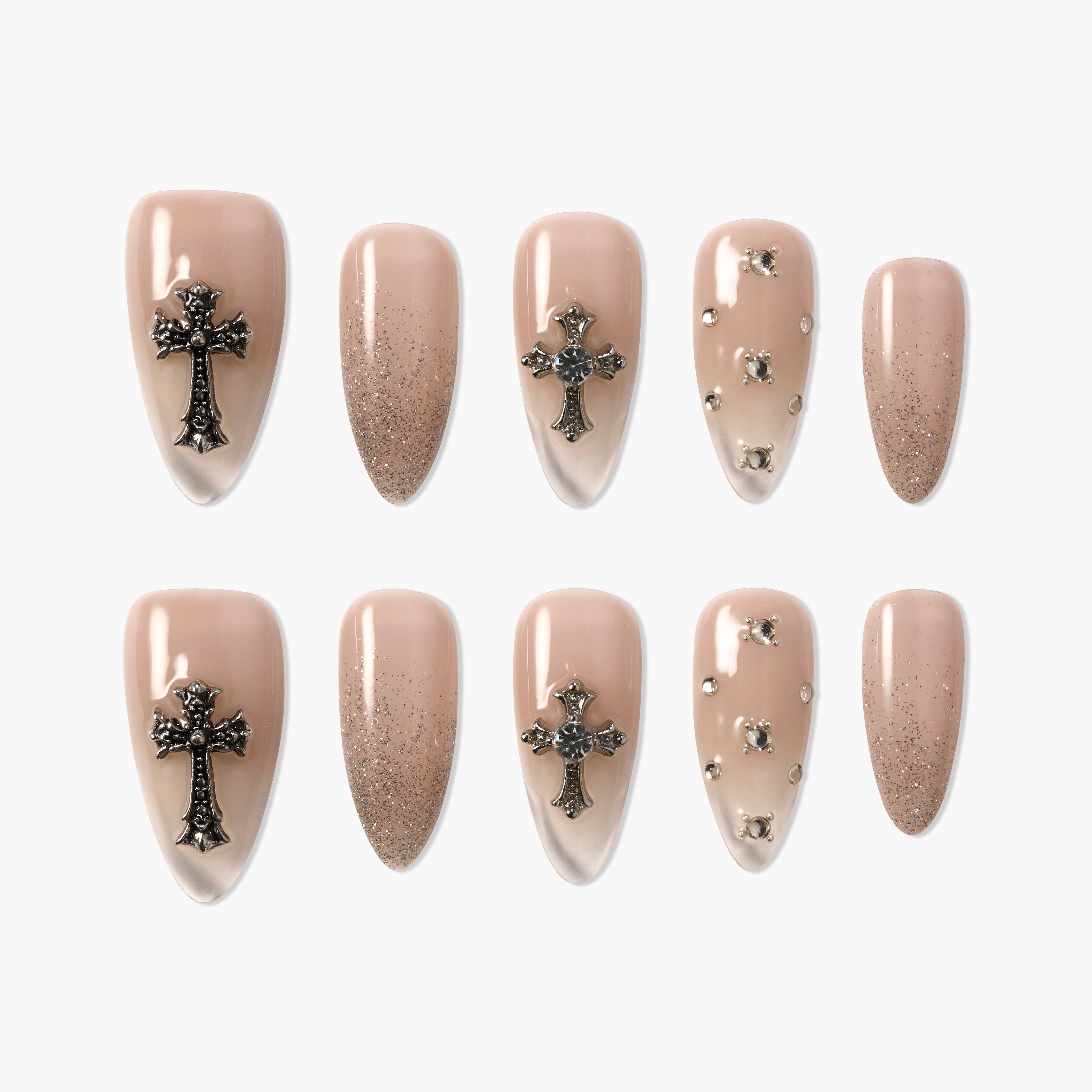 Set of nude press-on nails with metallic cross charms, rhinestones, and glitter details