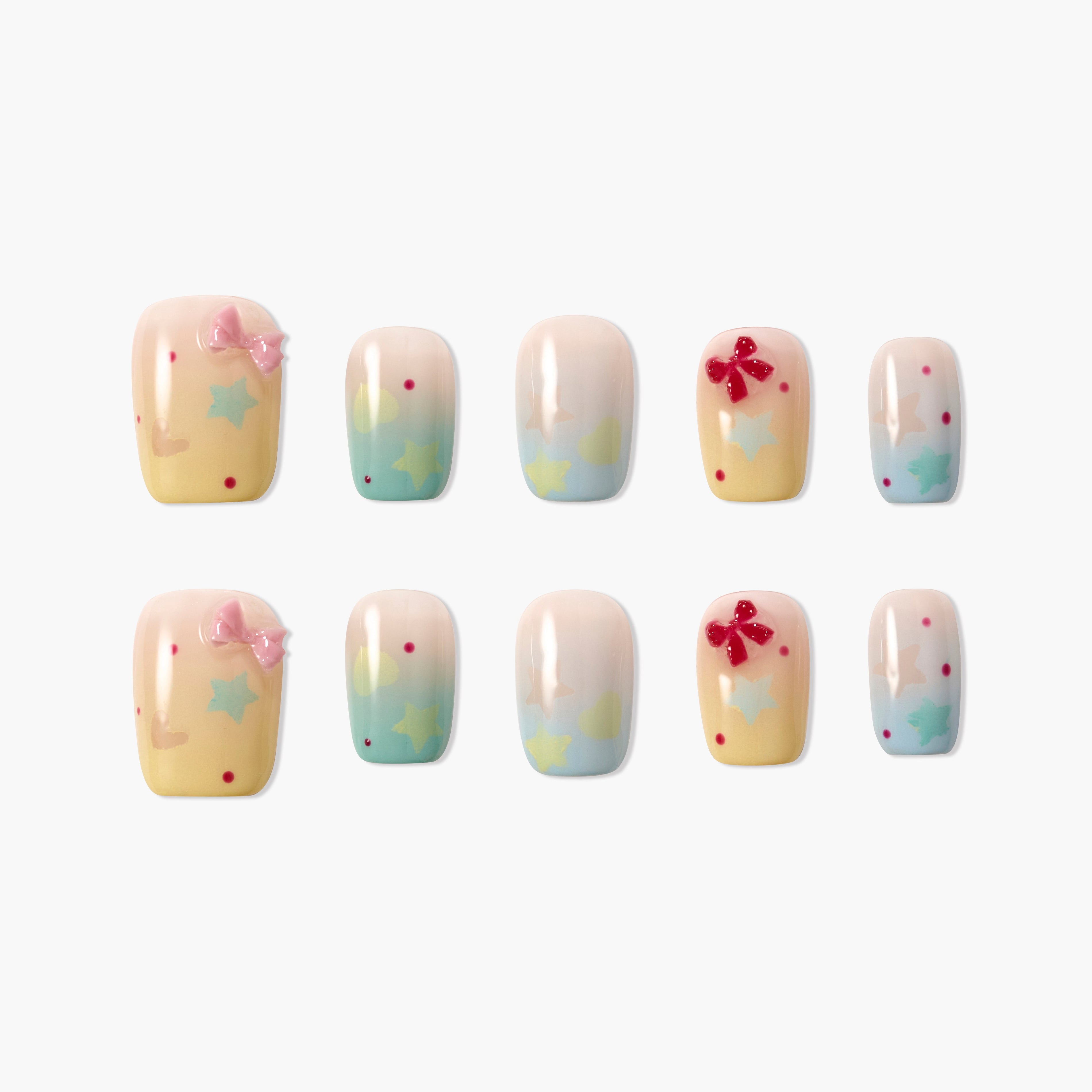 Set of pastel ombre press-on nails with star patterns, red and pink 3D bows on white background