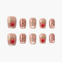 Handmade press-on nails with nude base, red strawberry art, polka dots, and gem accents.