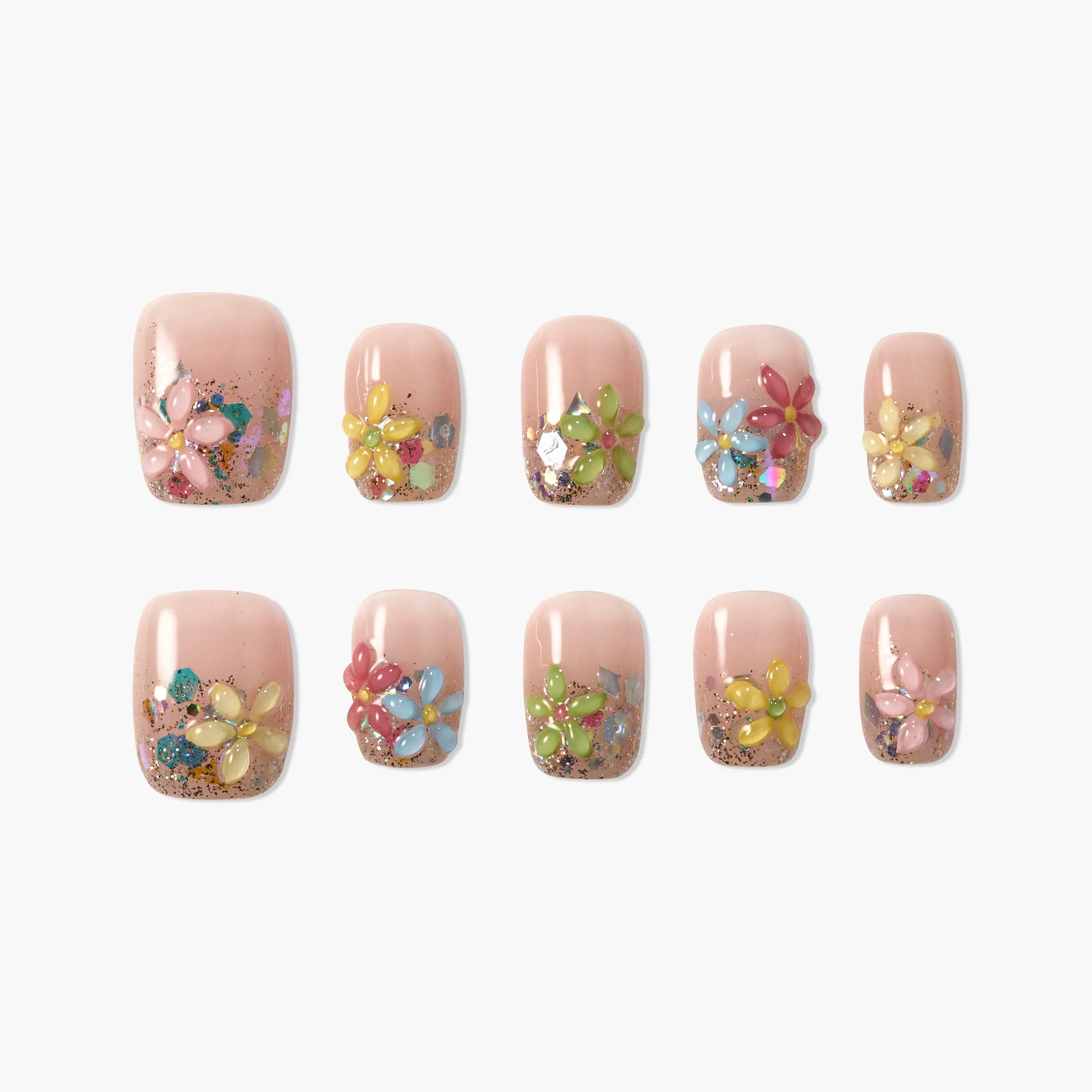 Set of nude press-on nails with colorful 3D flower designs and glitter accents