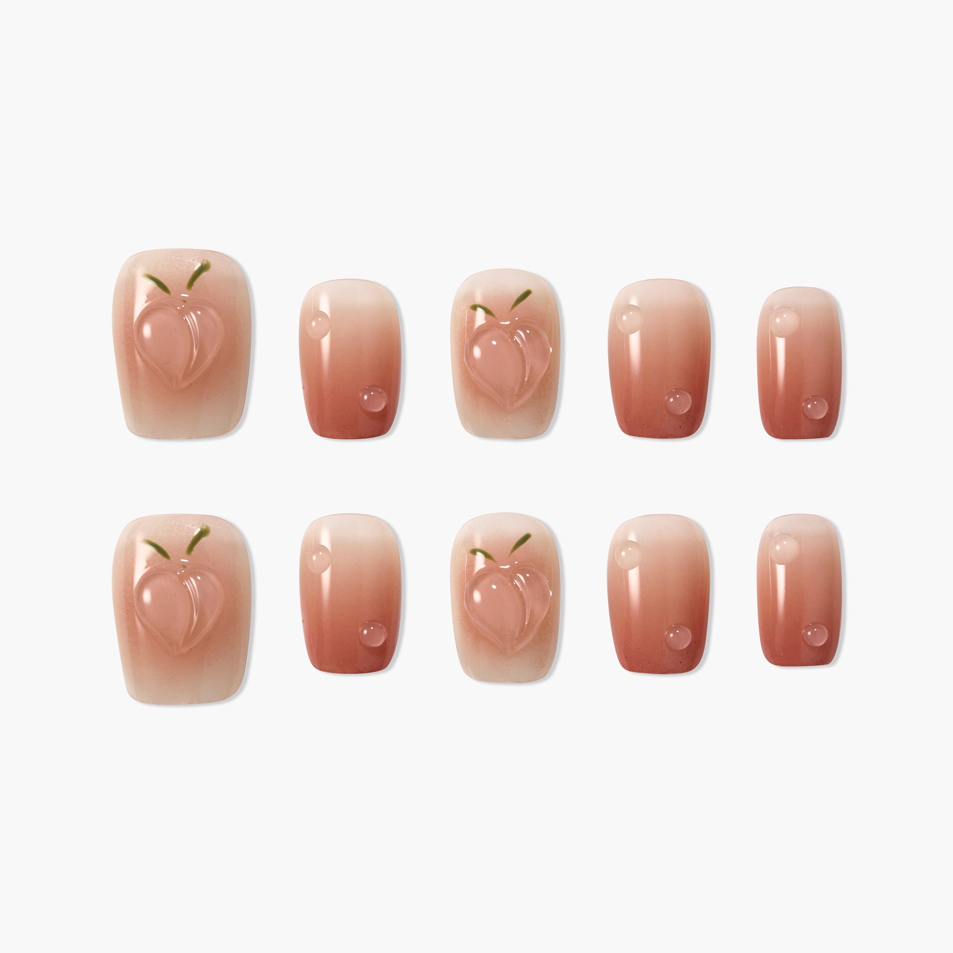 Set of nude ombre press-on nails with glossy 3D peach and droplet designs