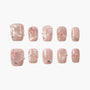 Pink press-on nails with 3D bows, pearl accents, rhinestones, and floral details