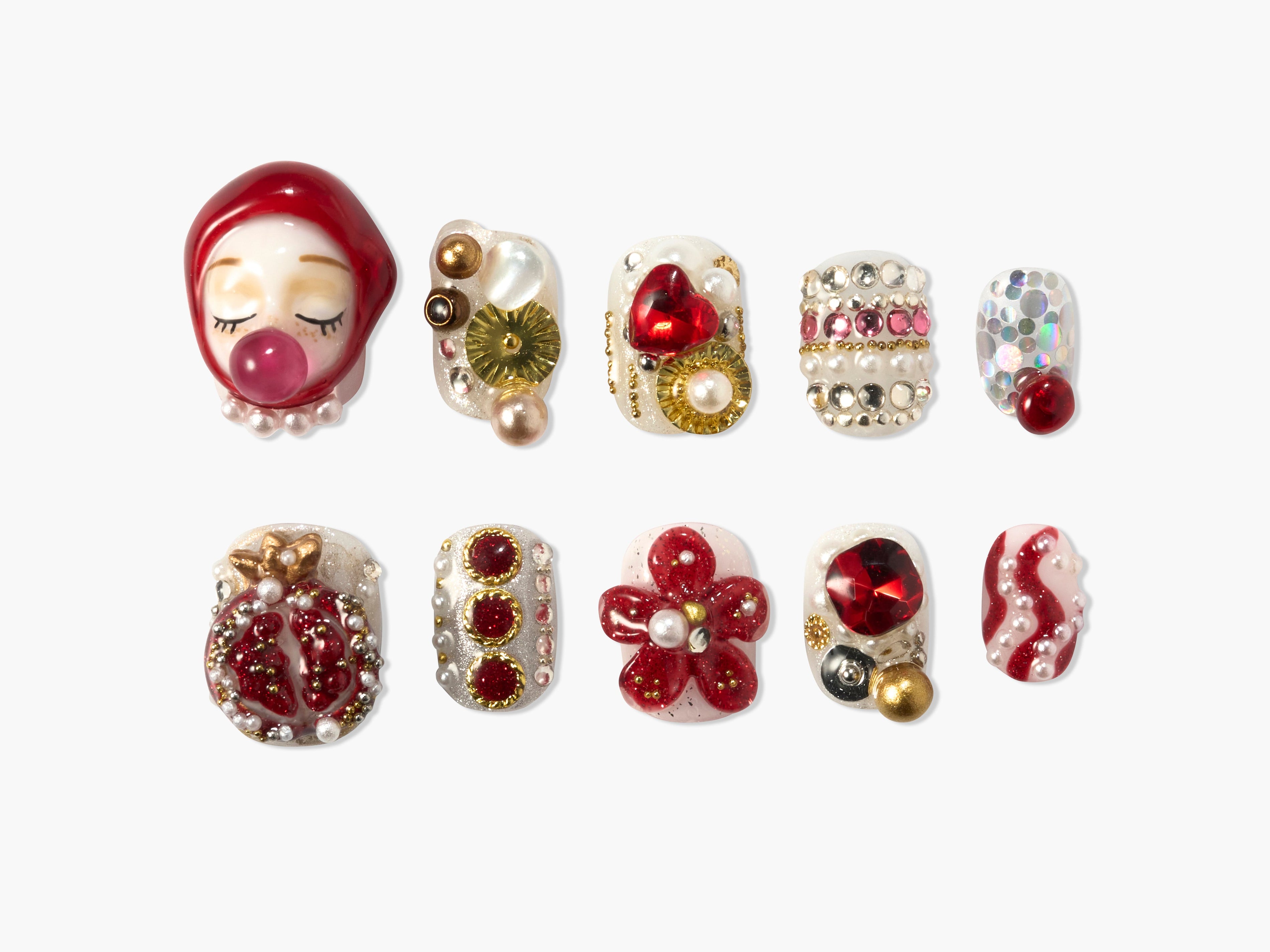 Set of 10 intricate press-on nails with red, gold, pearls, heart, flower, and glitter designs on white background
