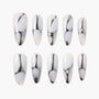 Set of 10 white and silver abstract patterned press-on nails on white background
