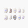 Set of 10 white press-on nails with blue designs including bows, hearts, dog faces, plaid, and handwritten words