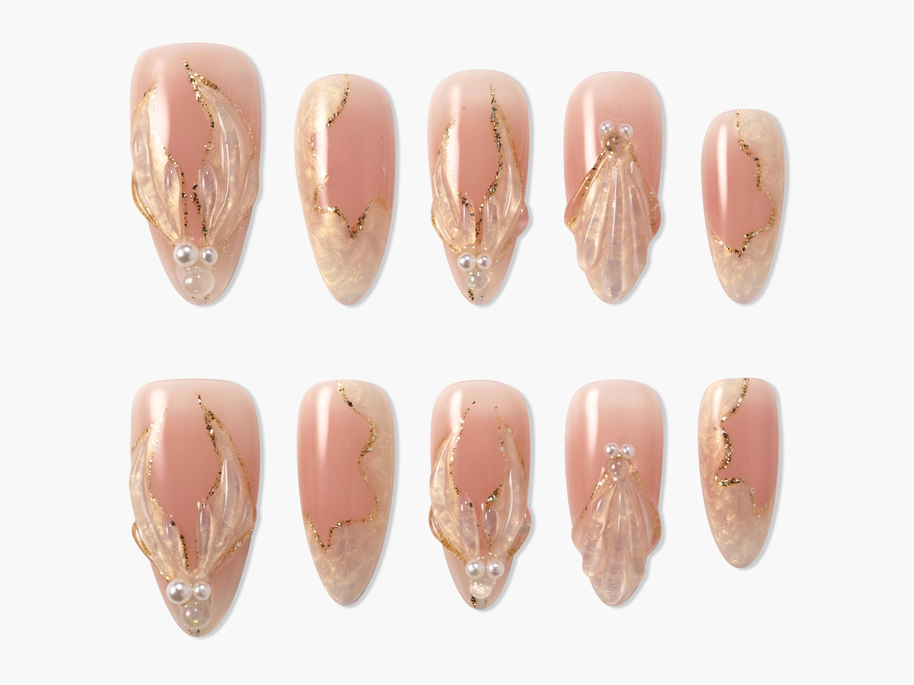 Handmade press-on nails in nude pink with 3D gold accents, pearl details, and marble design