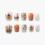 Halloween-themed press on nails with pumpkin, spider web, candy, and Halloween text designs