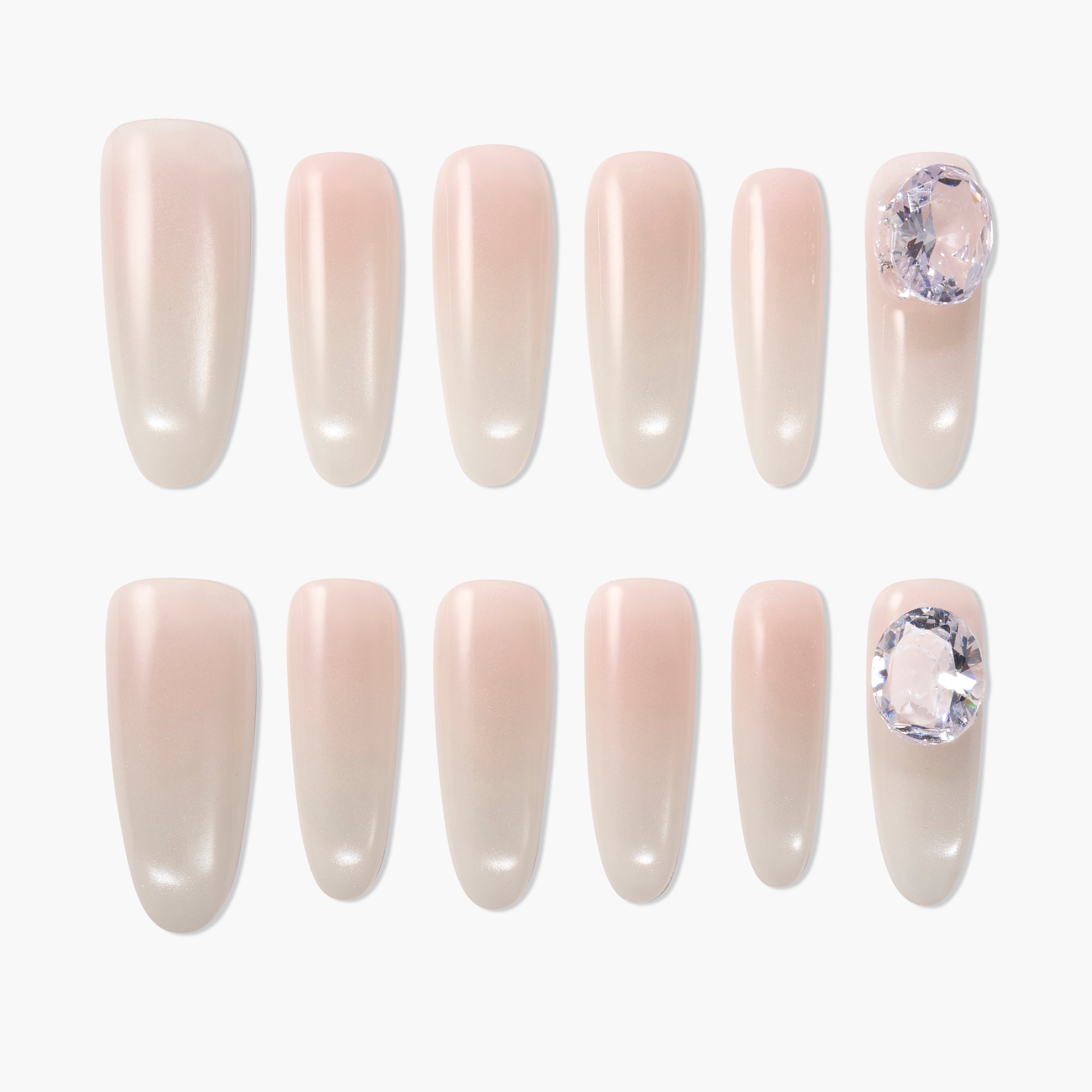 set of pink ombre press on nails with two nails featuring large crystal embellishments