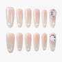 Set of nude pink press-on nails with glossy finish and crystal embellishments on two nails