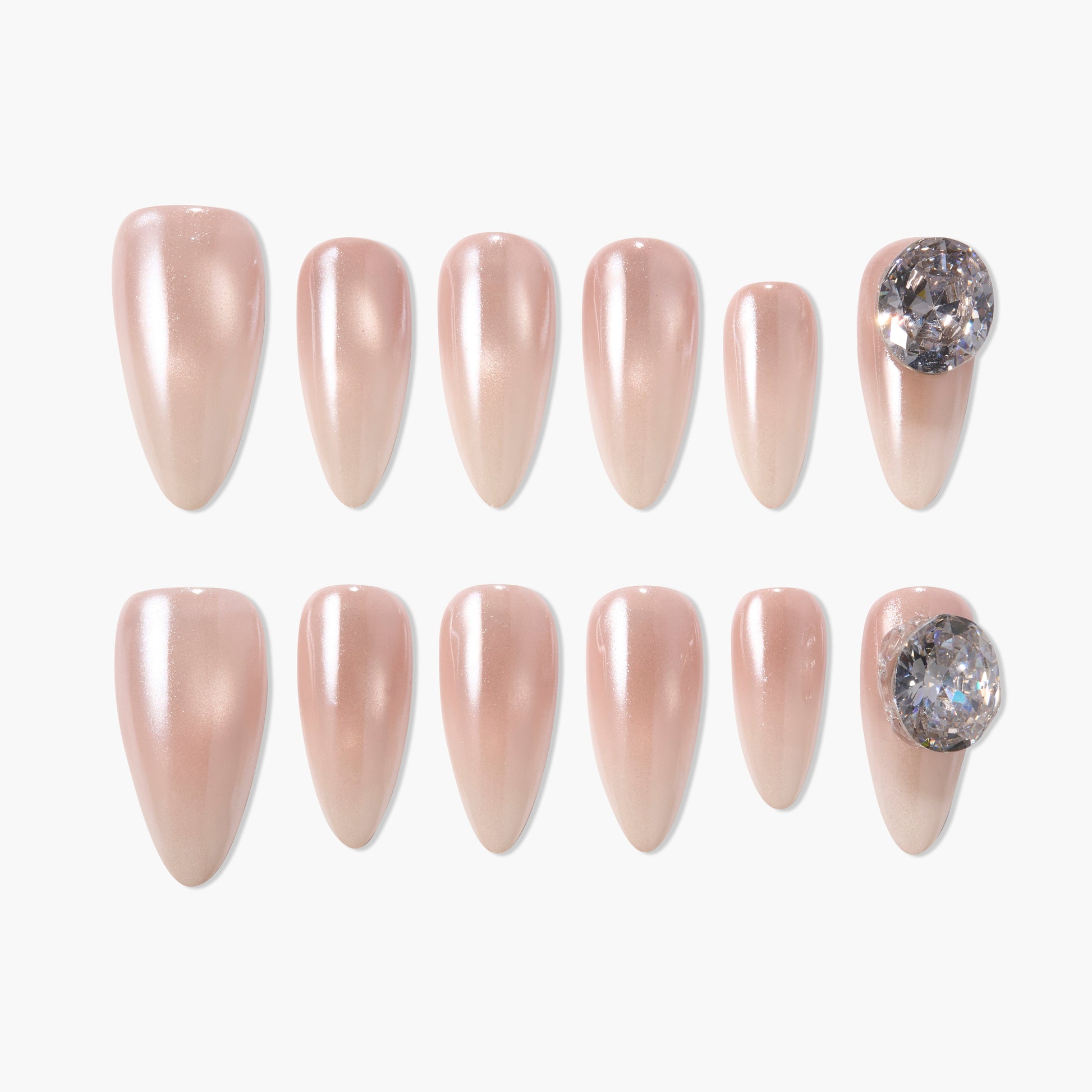 Set of pearlescent nude press-on nails with large rhinestone accents on two nails