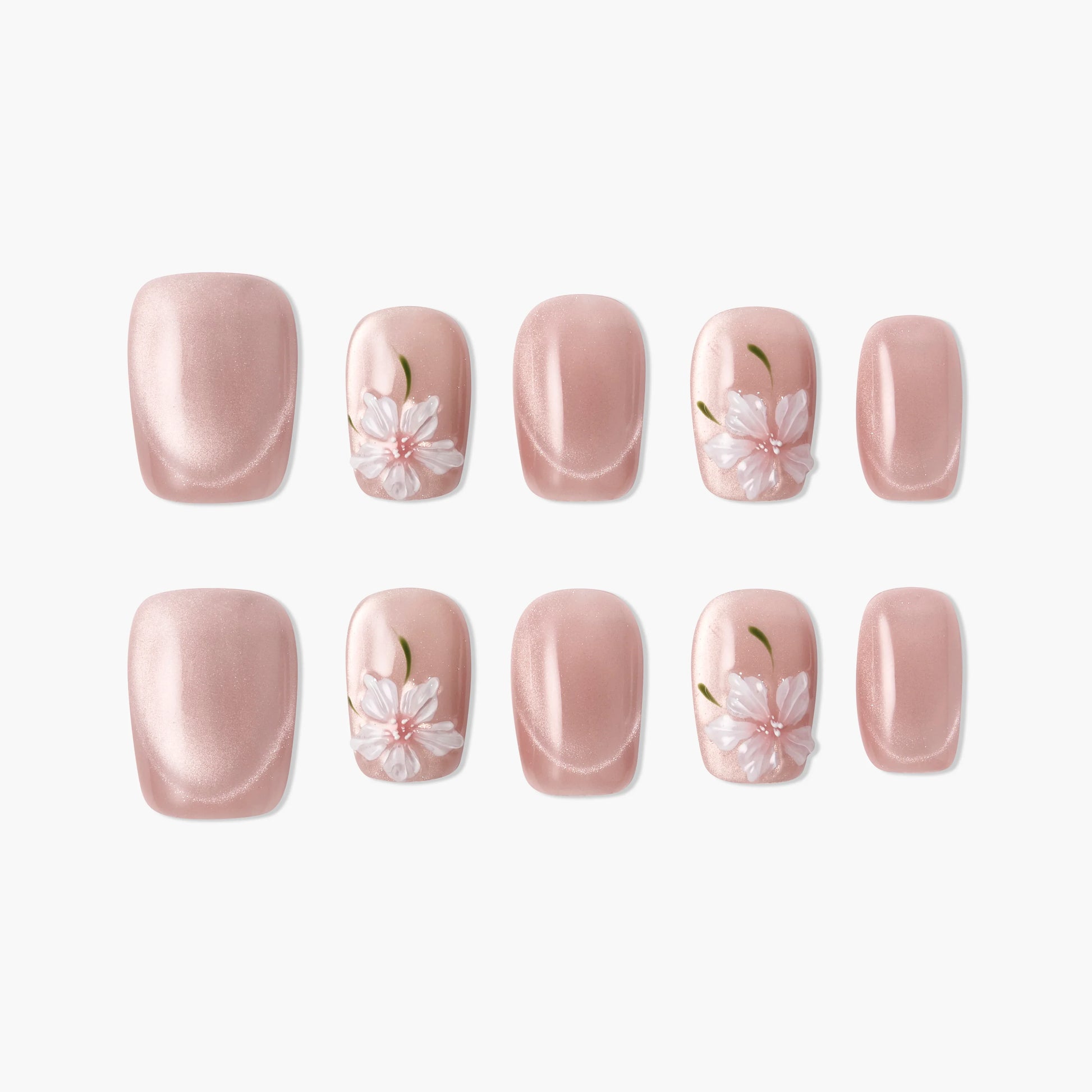 Pink press-on nails with white 3D floral designs and green accents, glossy finish