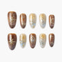 Handmade press-on nails with brown and gold celestial designs, stars, moons, and hearts