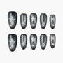 Glossy black press-on nails with glittery silver star design, displayed on white background.