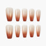 Set of handmade press-on nails with shimmery brown to nude ombre design on white background