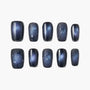 Handmade press-on nails with dark blue galaxy design, star accents, and glossy finish