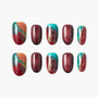 Handmade press-on nails with red, turquoise, and gold abstract swirl design.