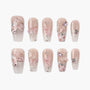 Handmade press-on nails with pink bows, 3D hearts, gems, and glitter accents on a nude base.