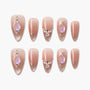 Handmade almond press-on nails with nude ombre, iridescent gems, and gold star accents