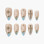 Beige and blue press-on nails with gold accents and rhinestone cross designs, set of ten