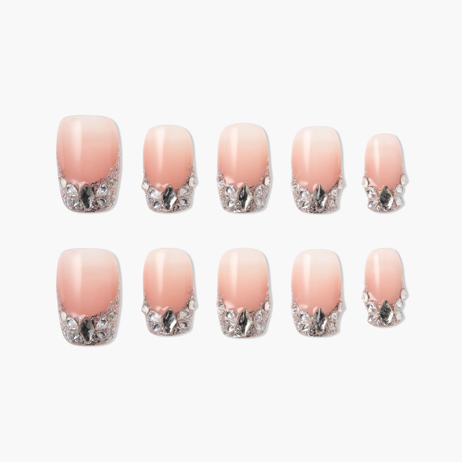 Set of pink ombre press-on nails with silver glitter and gem accents, arranged on white background