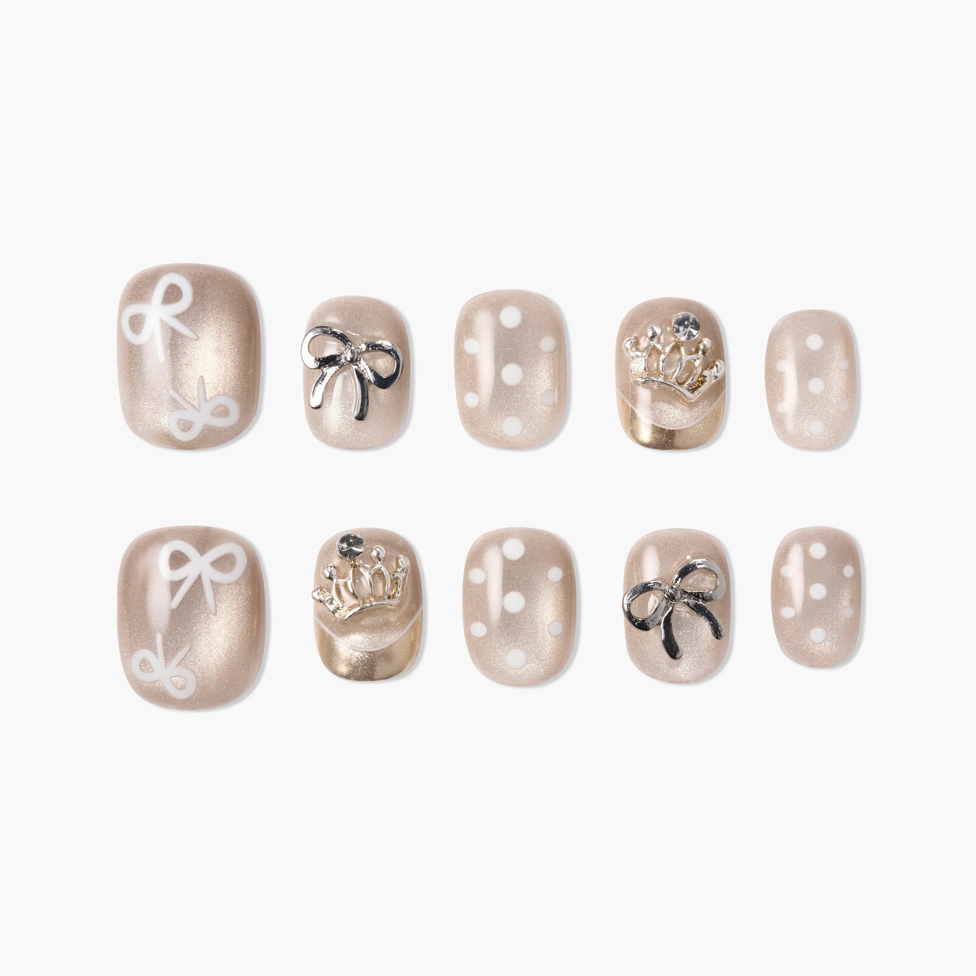 Beige press-on nails with bows, polka dots, and 3D crown accents, arranged on white background.