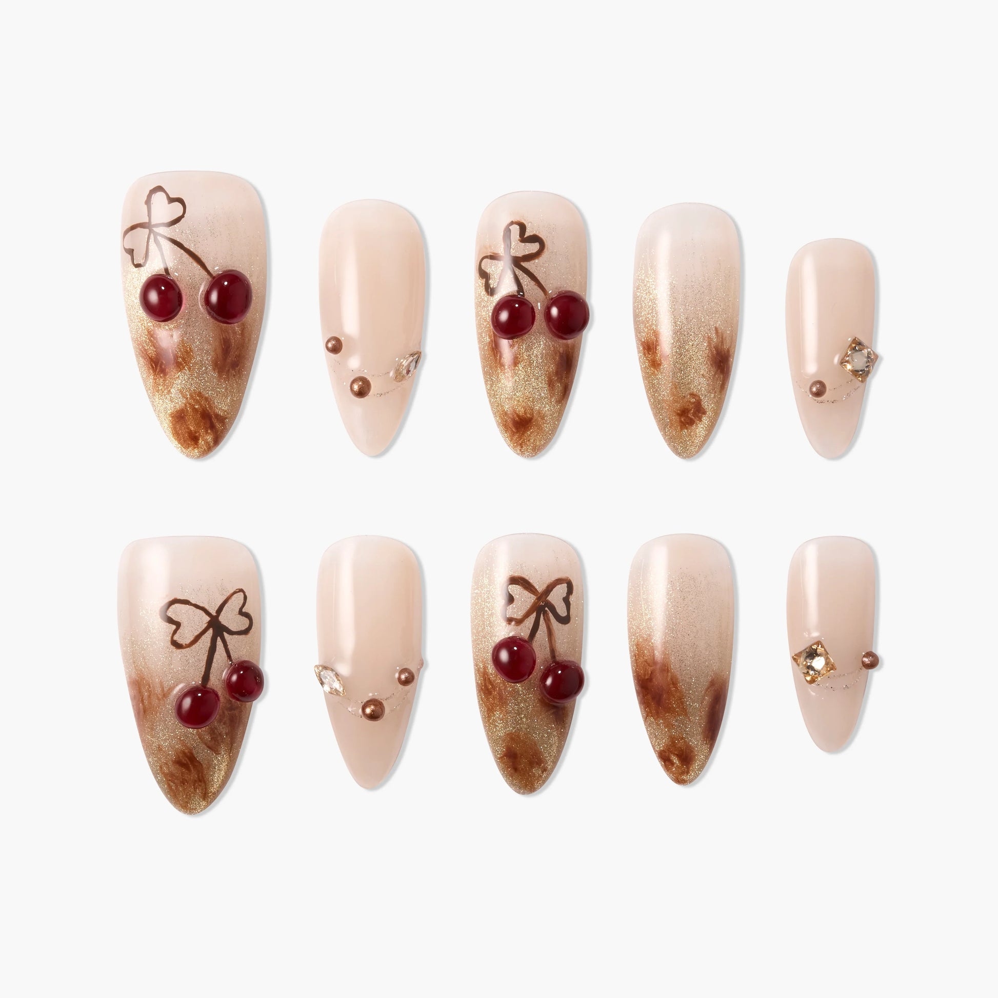 Handmade press-on nails with nude, gold marble design and cherry accents with bows