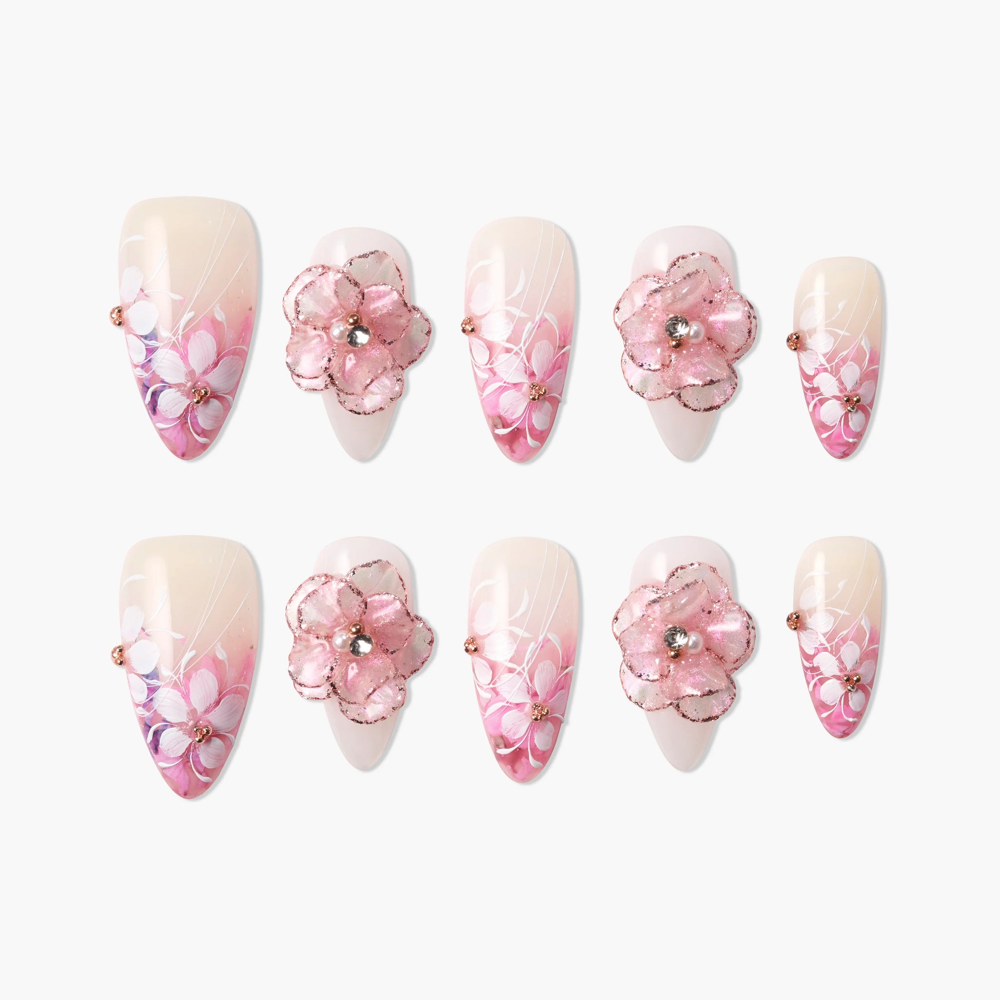 Pink floral press-on nails with 3D flower accents, gradient tips, and sparkling rhinestones.