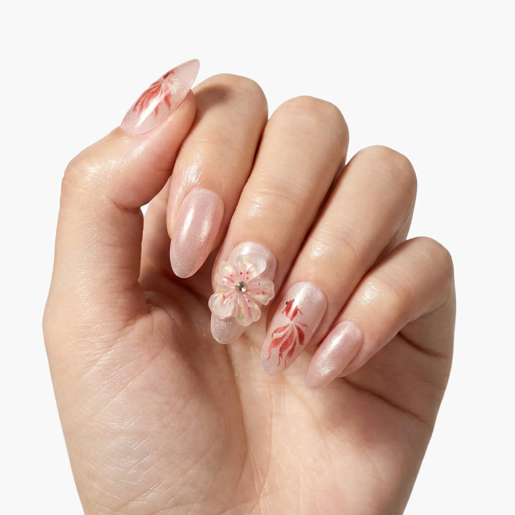 Hand with almond-shaped press-on nails in shimmery pink, floral and leaf nail art accents