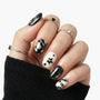 Hand with black and white geometric press-on nails featuring stars and stripes