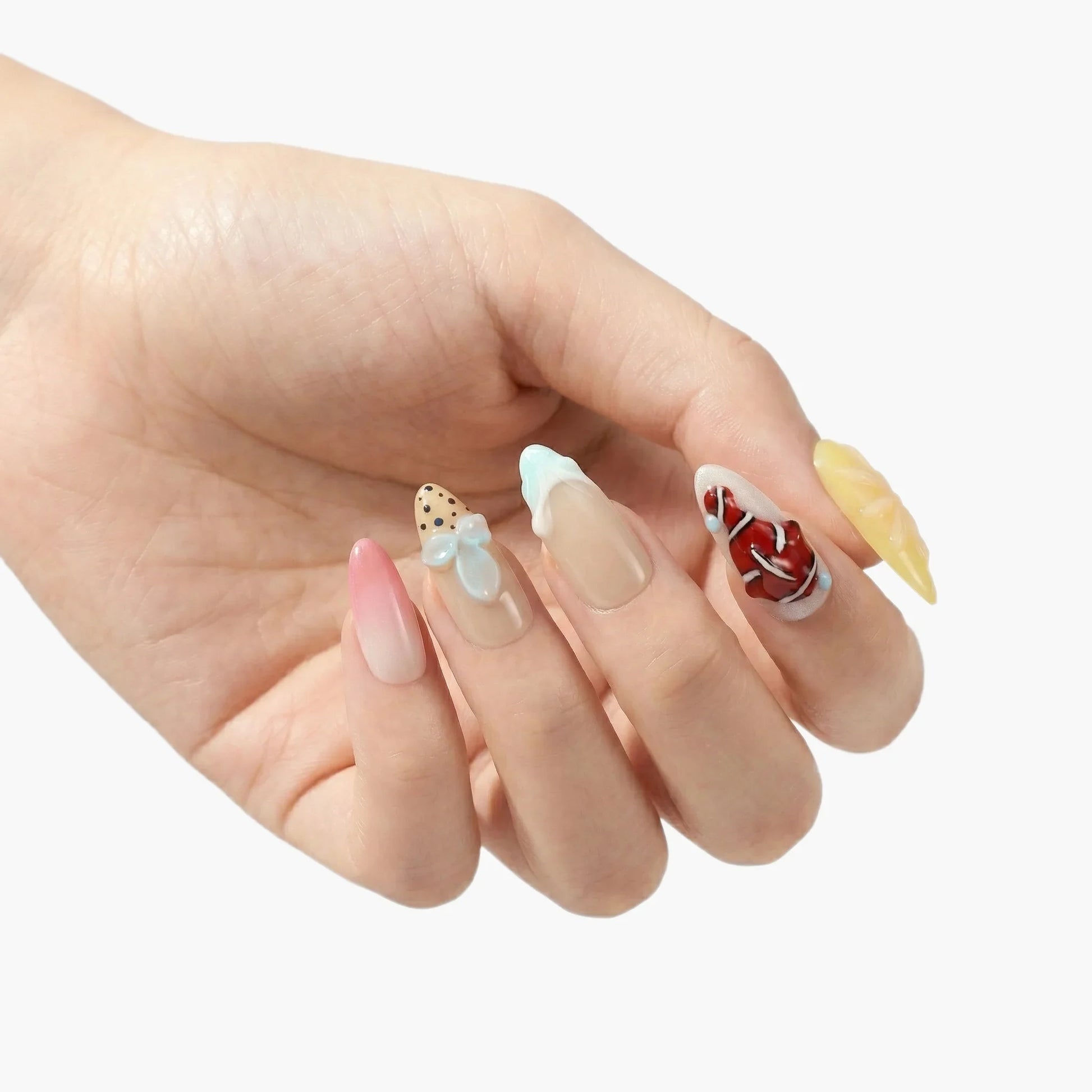 Hand with multicolored handmade press-on nails featuring 3D bows, swirls, and playful designs.