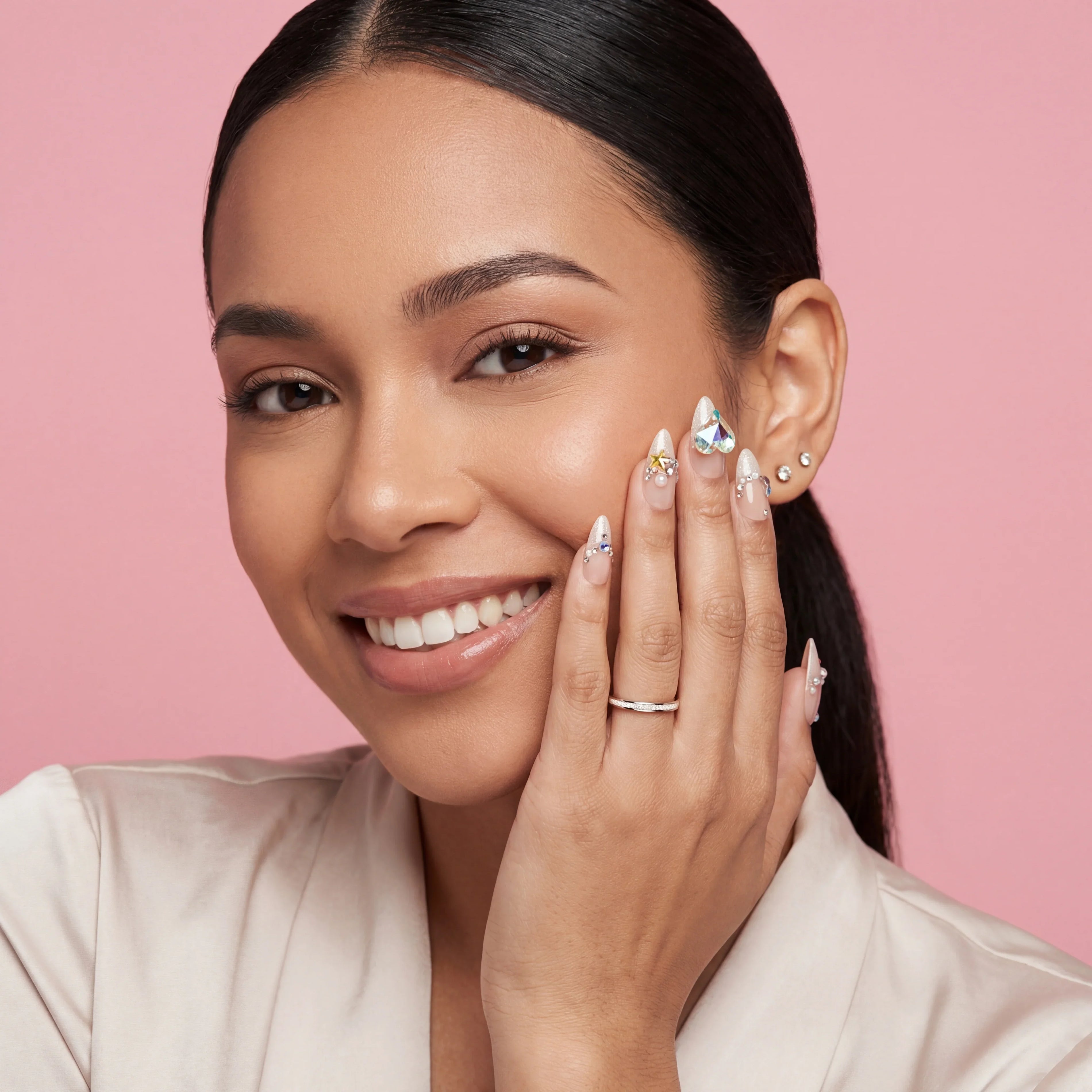 Woman smiling with long, almond-shaped press-on nails featuring diamond and pearl accents