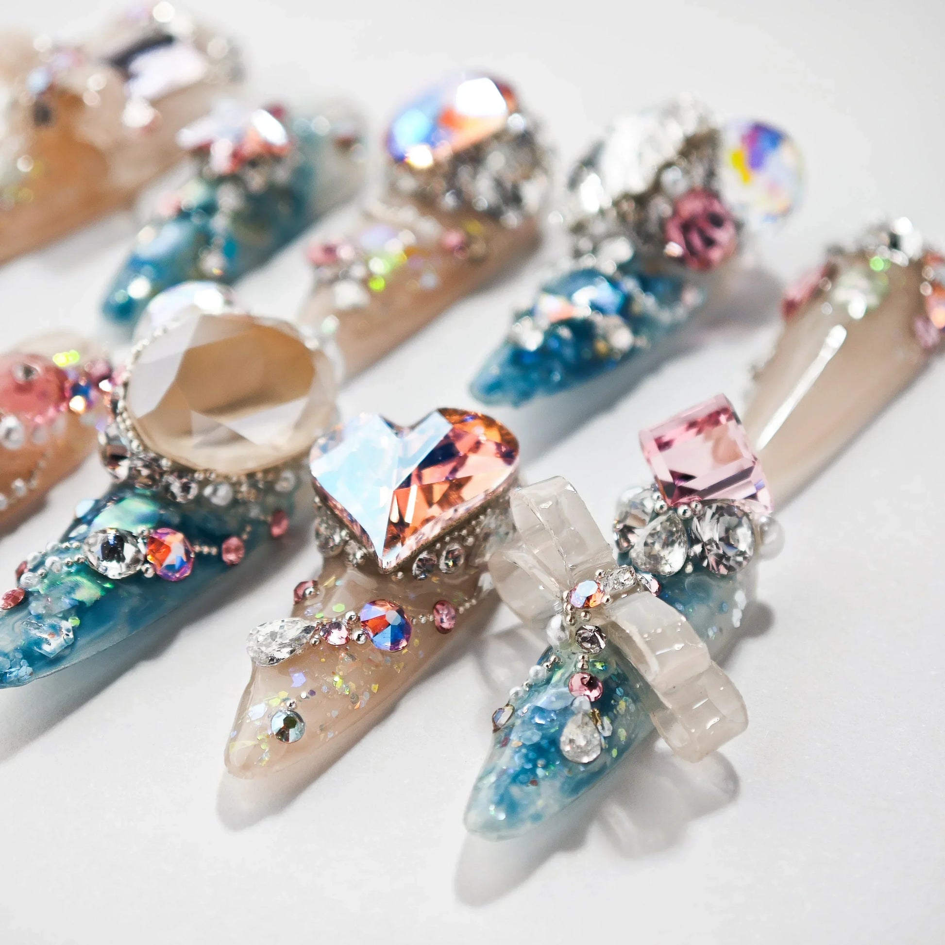 Set of blue and beige long acrylic nails with large crystals and glitter nail art