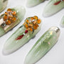 Handmade light green press-on nails with gold foil, floral 3D art, and gemstone details