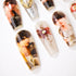 Set of custom press-on nails with printed male portraits and decorative floral and metallic designs